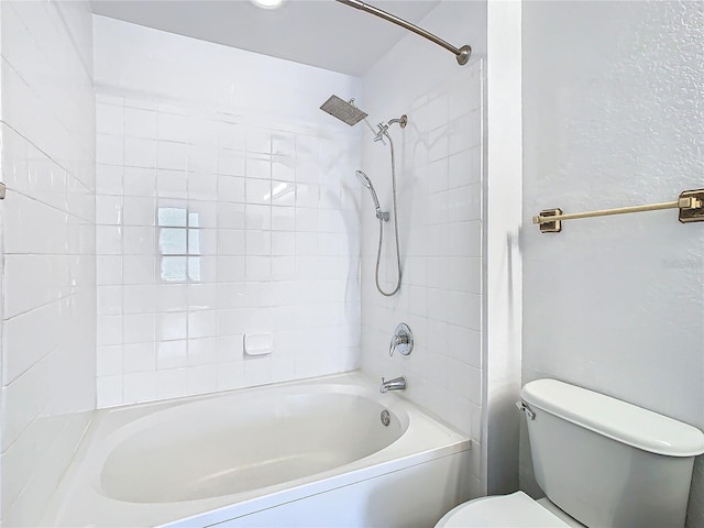 bathroom with toilet and tiled shower / bath