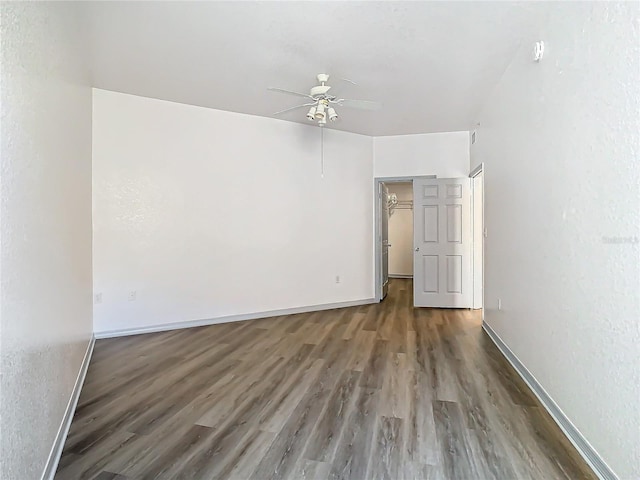 unfurnished room with dark wood-type flooring and ceiling fan