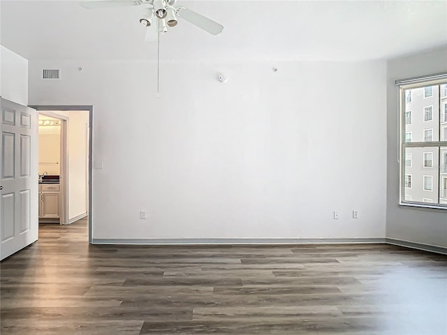 spare room featuring dark hardwood / wood-style flooring and ceiling fan