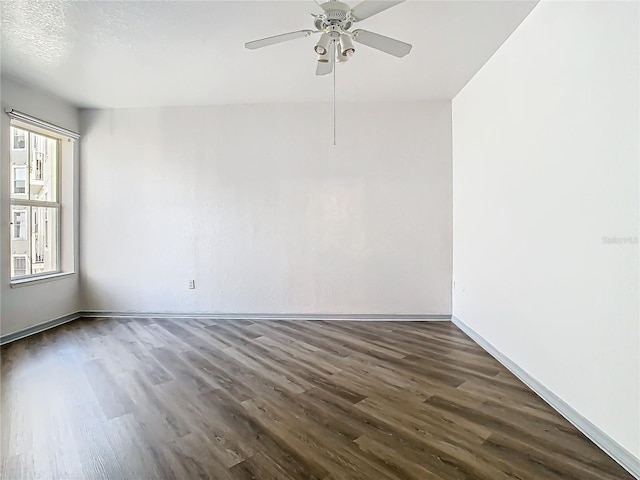 empty room with dark hardwood / wood-style flooring and ceiling fan