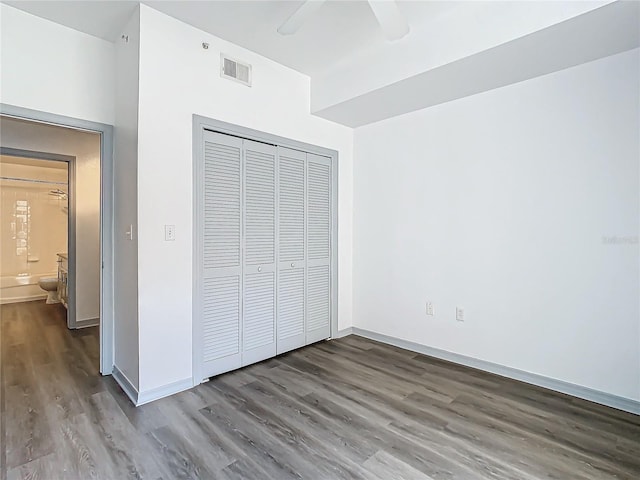 unfurnished bedroom featuring wood-type flooring, a closet, and ceiling fan