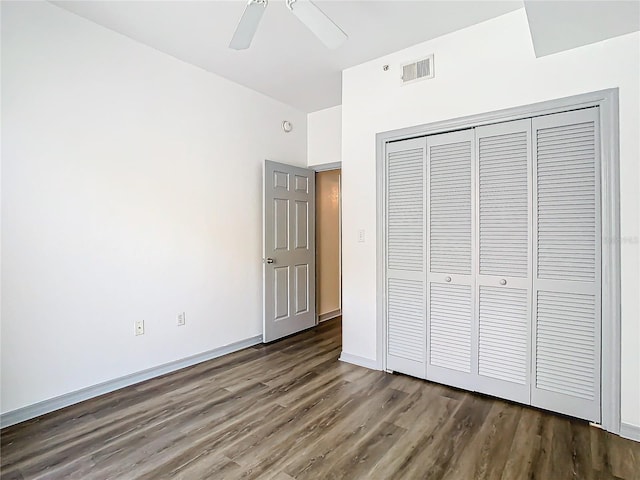 unfurnished bedroom with ceiling fan, a closet, and dark hardwood / wood-style floors