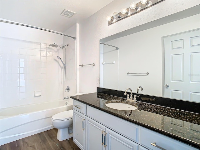 full bathroom featuring washtub / shower combination, hardwood / wood-style floors, vanity, and toilet