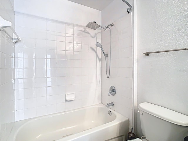 bathroom with toilet and tiled shower / bath