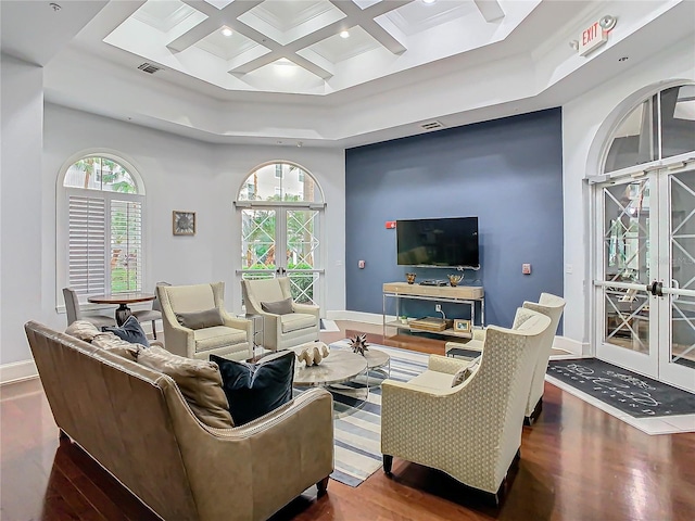 living room featuring dark hardwood / wood-style floors, french doors, a towering ceiling, beam ceiling, and coffered ceiling