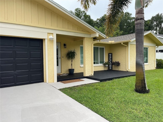 property entrance with a garage and a lawn