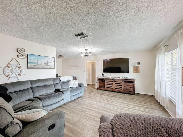 living room with a textured ceiling and light hardwood / wood-style floors