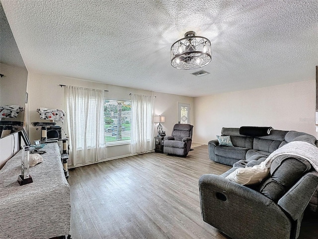 living room featuring a textured ceiling and light wood-type flooring