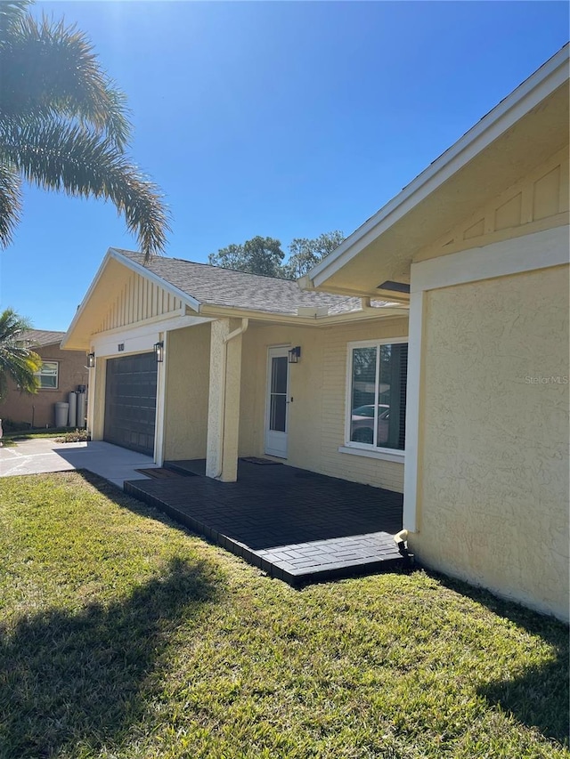 view of property exterior with a garage and a yard