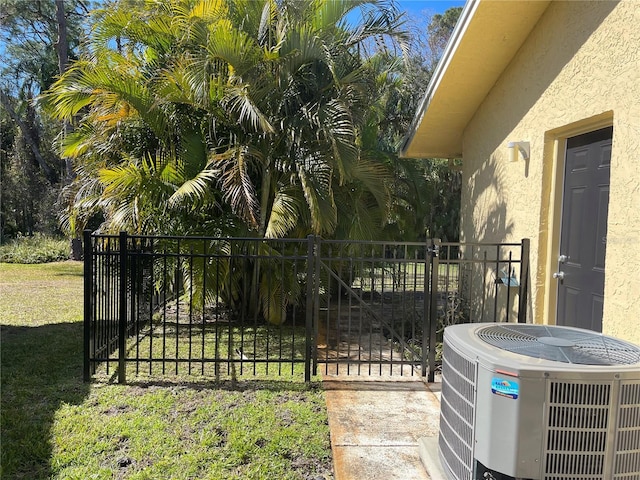 view of gate featuring central AC and a lawn