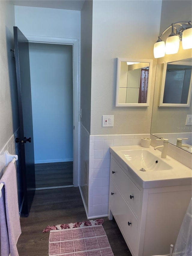 bathroom featuring hardwood / wood-style flooring, vanity, and tile walls