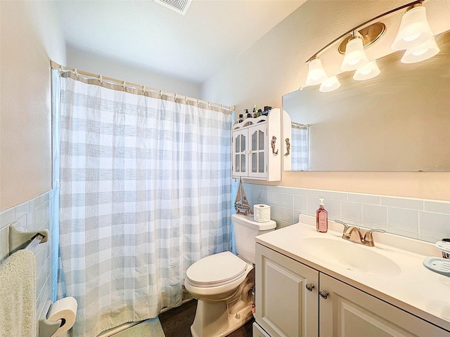 bathroom with tile walls, decorative backsplash, vanity, walk in shower, and toilet