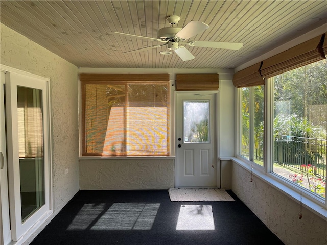 unfurnished sunroom with wood ceiling, a wealth of natural light, and ceiling fan