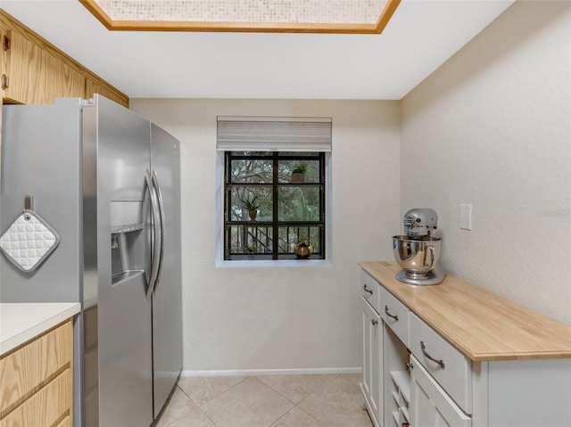 kitchen featuring light tile patterned floors and stainless steel fridge