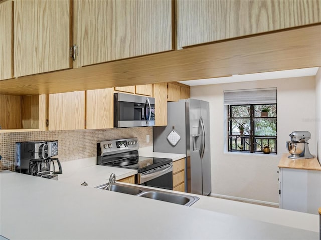 kitchen with sink, stainless steel appliances, backsplash, and light brown cabinets