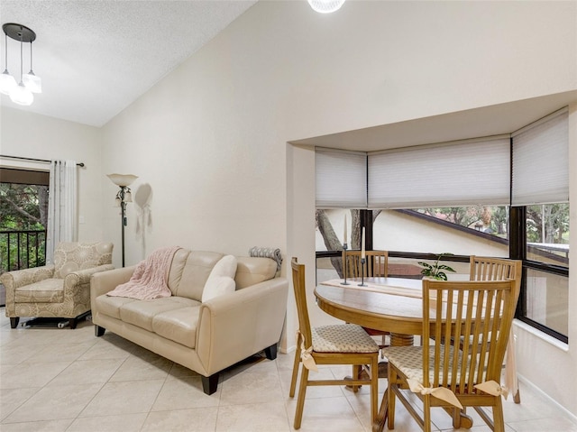 living room featuring a textured ceiling, light tile patterned flooring, vaulted ceiling, and a healthy amount of sunlight