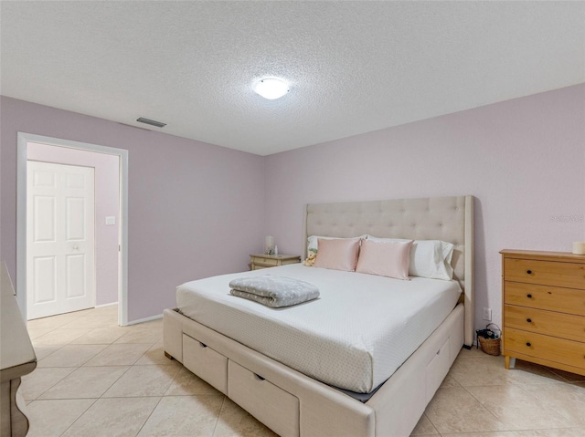 tiled bedroom featuring a textured ceiling