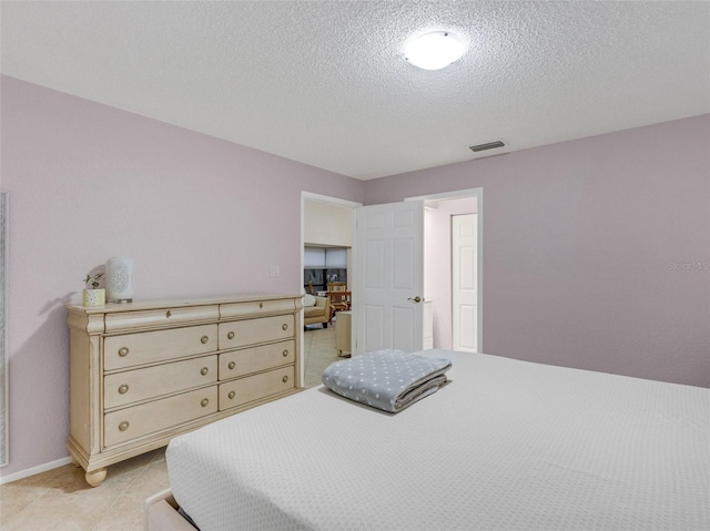 tiled bedroom featuring a textured ceiling