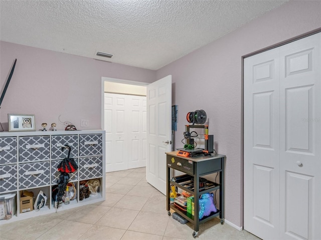 interior space with light tile patterned flooring and a textured ceiling