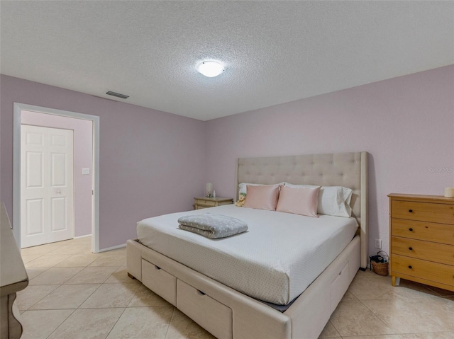 bedroom with light tile patterned floors and a textured ceiling