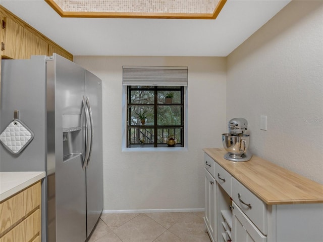 kitchen featuring stainless steel fridge with ice dispenser and light tile patterned floors