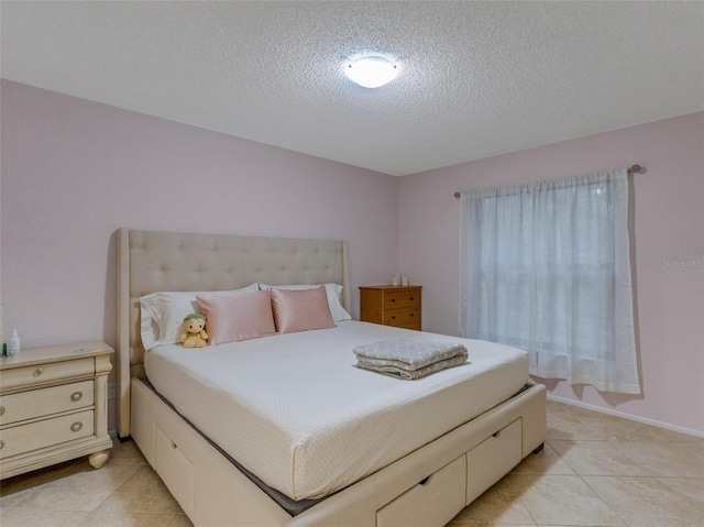 bedroom featuring light tile patterned flooring and a textured ceiling