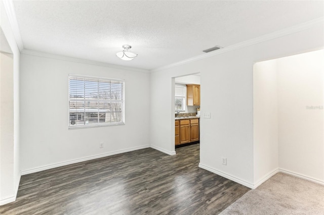 empty room featuring ornamental molding, a textured ceiling, and dark hardwood / wood-style flooring