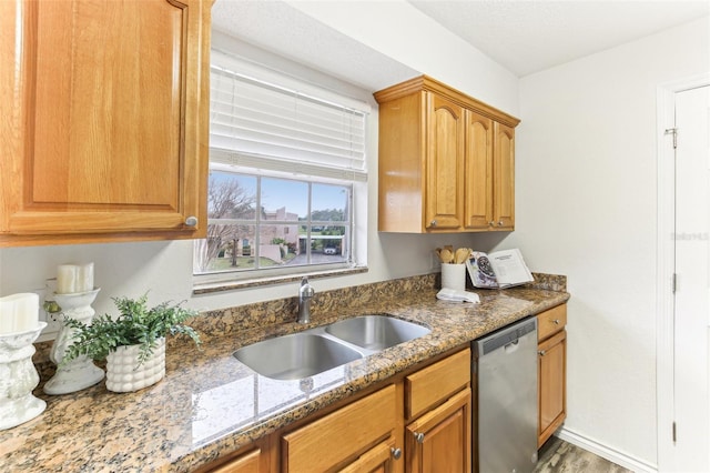 kitchen featuring sink, dark stone counters, and dishwasher