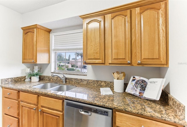 kitchen featuring dishwasher, sink, and dark stone counters