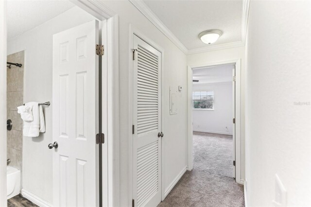 corridor with crown molding and light carpet