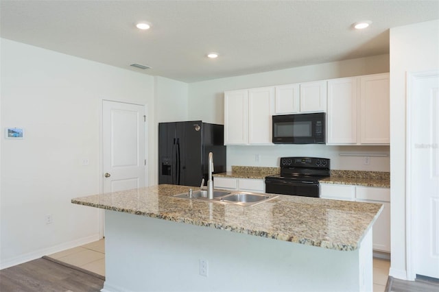 kitchen with sink, an island with sink, white cabinetry, and black appliances