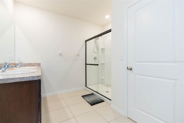 bathroom featuring tile patterned floors, vanity, and a shower with door