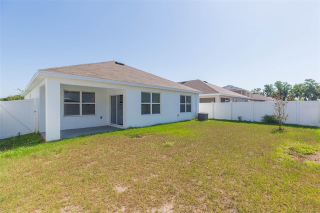 rear view of property with a lawn and central AC unit