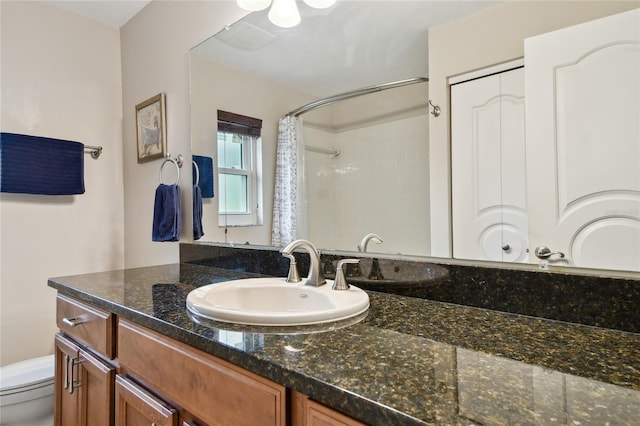 bathroom featuring toilet, vanity, and a shower with curtain