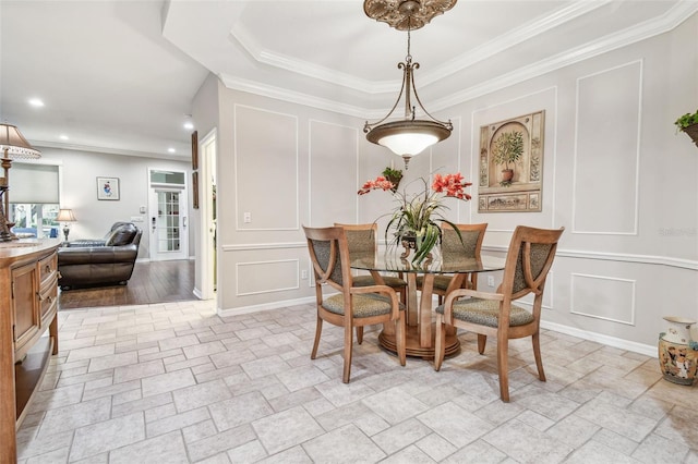 dining area featuring a tray ceiling, sink, and crown molding