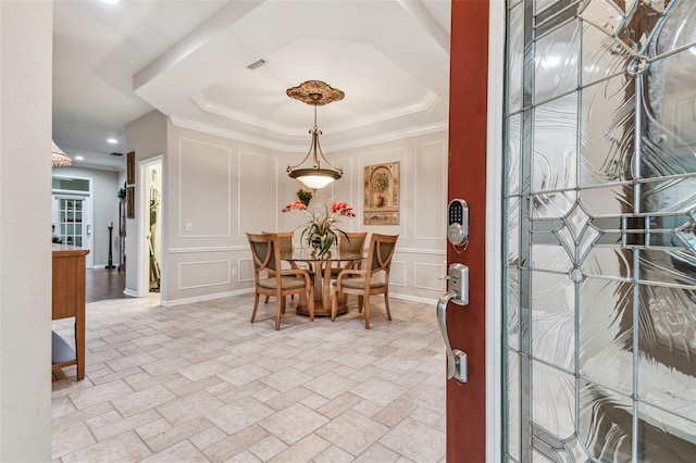 dining space featuring ornamental molding and a tray ceiling