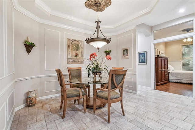 dining room with a raised ceiling and crown molding