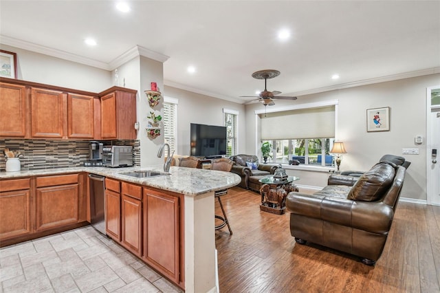 kitchen featuring sink, decorative backsplash, stainless steel dishwasher, and kitchen peninsula