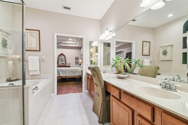 bathroom featuring vanity, tiled tub, and tile patterned floors