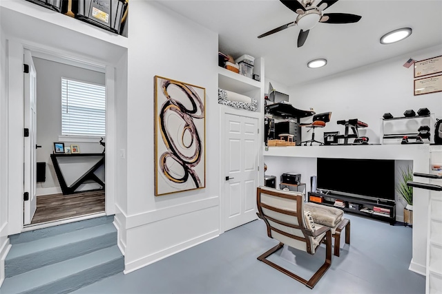 office space featuring ceiling fan and built in shelves