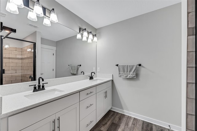 bathroom with a shower with shower door, vanity, and hardwood / wood-style floors