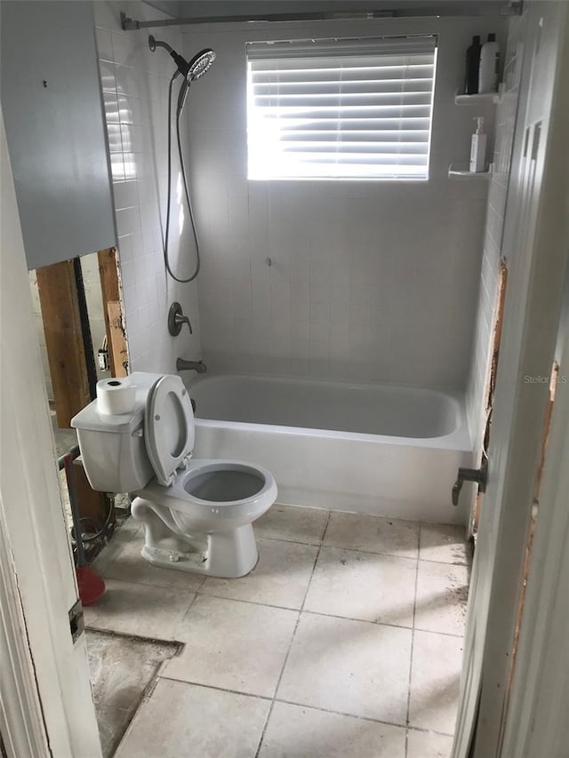 bathroom with toilet, tile patterned flooring, and tiled shower / bath combo