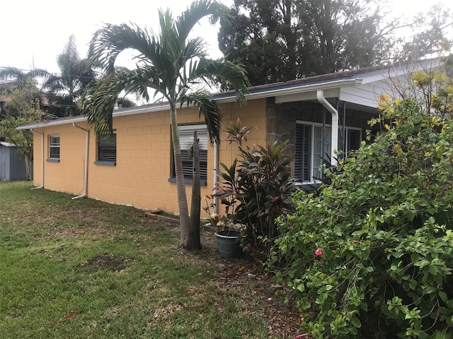 view of side of home with a yard