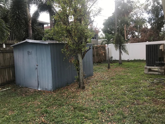 view of yard featuring a shed and central AC unit