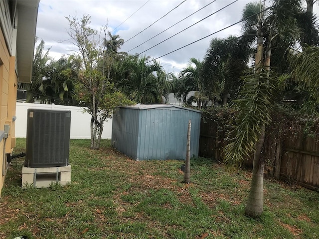 view of yard with central AC and a storage shed