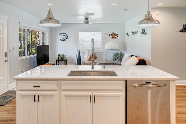 kitchen featuring sink, light wood-type flooring, stainless steel dishwasher, and light stone countertops