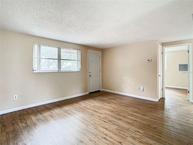 empty room featuring wood-type flooring and a textured ceiling