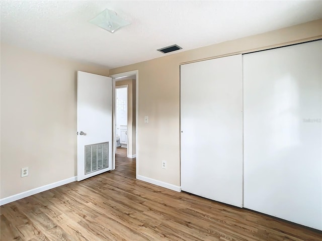 unfurnished bedroom featuring a closet and light wood-type flooring