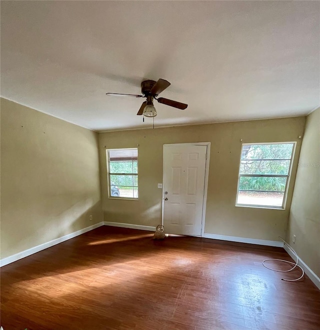 unfurnished room with ceiling fan and dark hardwood / wood-style flooring