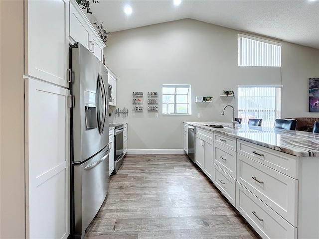 kitchen featuring sink, white cabinetry, appliances with stainless steel finishes, and kitchen peninsula